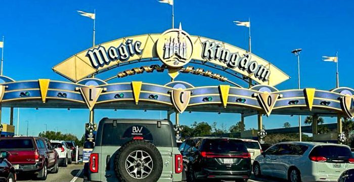 2023-wdw-atmos-mk-magic-kingdom-entrance-cars-driving-in-toll-booth-700x456.jpg